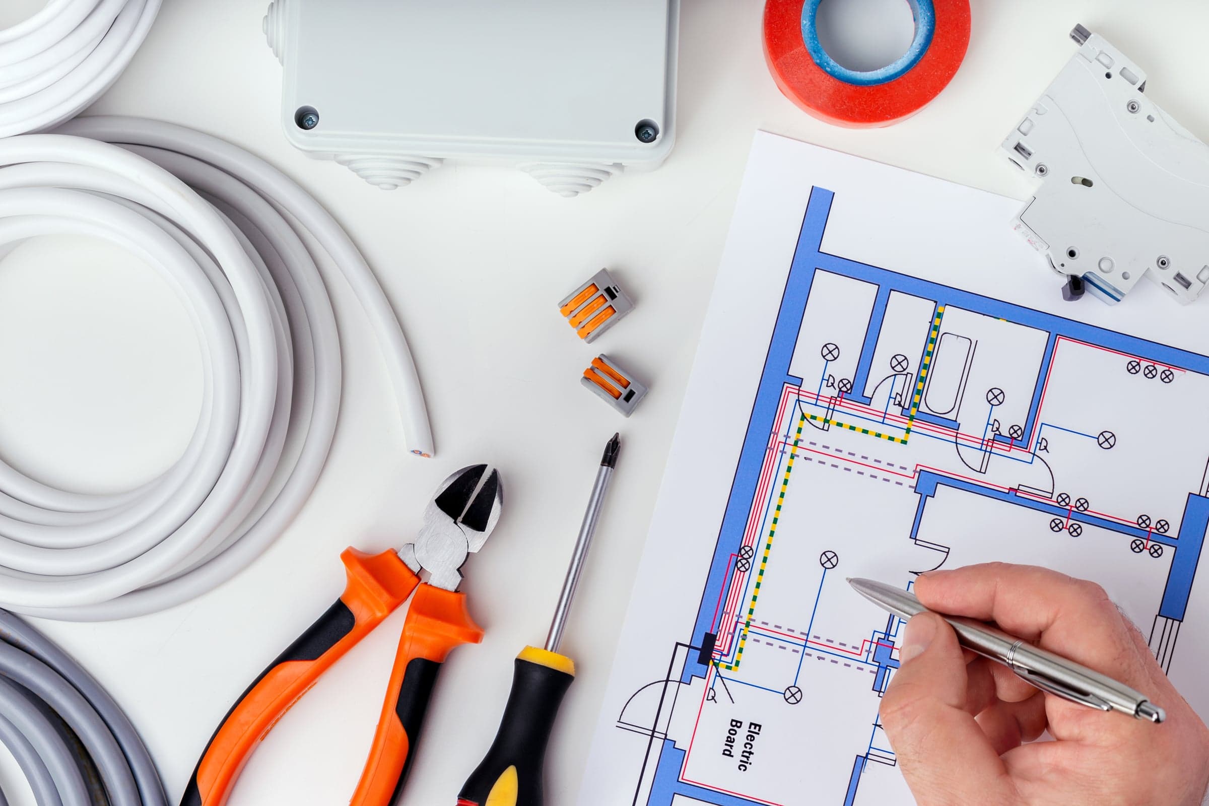 Elektroplan mit Leitungsführung, daneben Kabel, Abzweigdose, Klemmen, Leitungsschutzschalter und Werkzeug